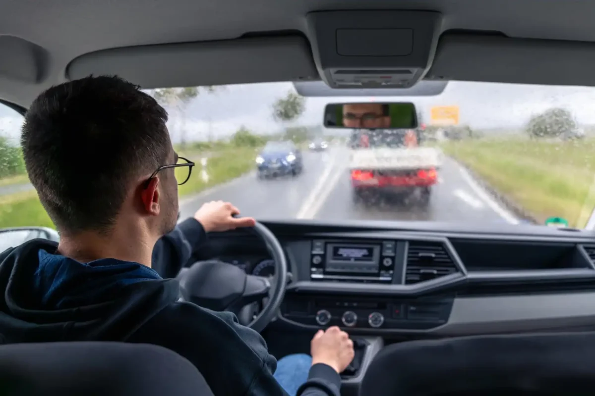 Driver following traffic on a rainy highway, illustrating highway driving anxiety.